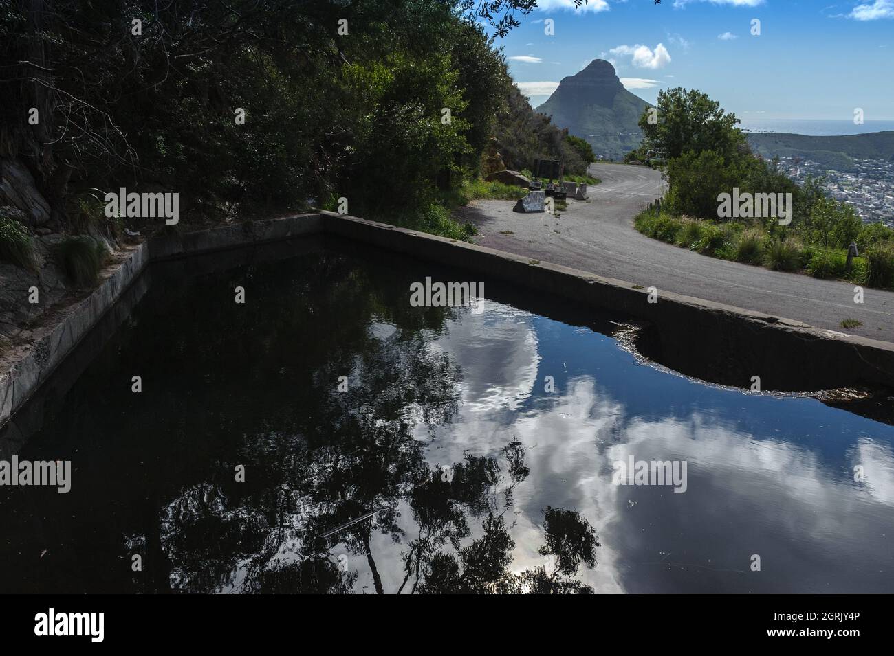 A small dam on a Table Mountain contour road overlooks another Cape Town landmark Lion's Head in South Africa's tourist capital Stock Photo