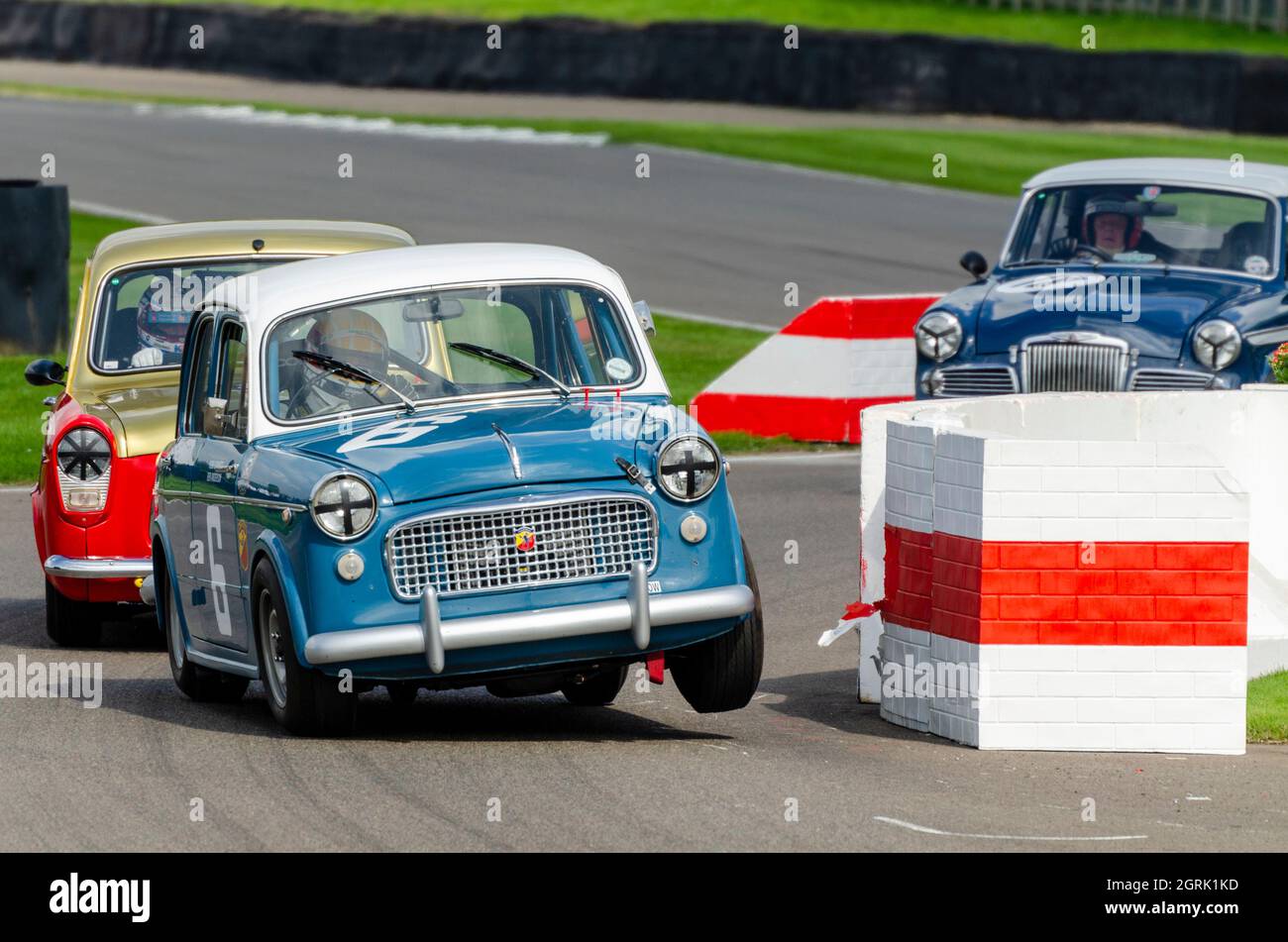 FIAT 1100 classic, vintage race car, racing in the St Mary’s Trophy for 1950s production saloons at the Goodwood Revival 2014. Powering out, wheel up Stock Photo