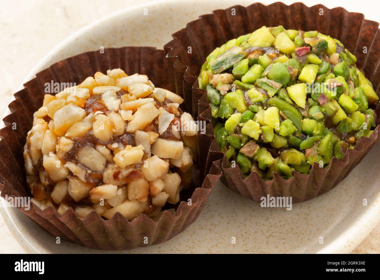 Pair of sweet Turkisch date bonbons decorated with nuts close up Stock Photo