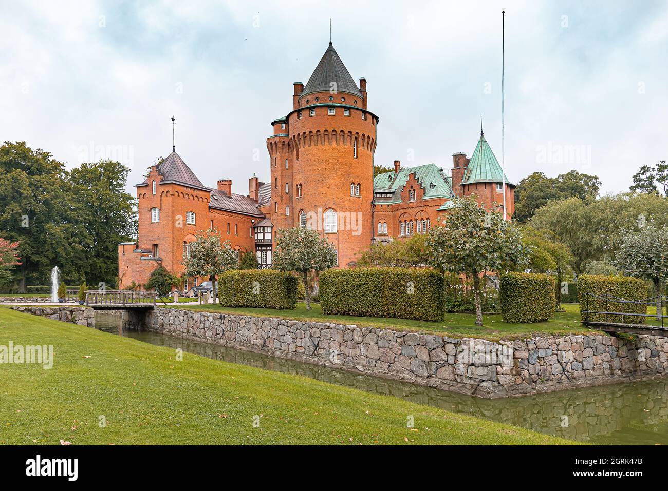 the tall tower of the fary tale castle Hjularod on a green lawn surrounded by a moat, Eslov, Sweden, September 16, 2021 Stock Photo