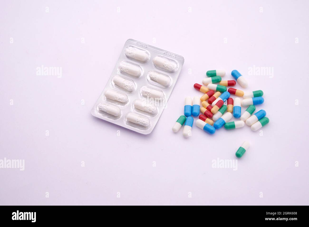 High Angle View Of Capsules And Blister Pack Over White Background Stock Photo