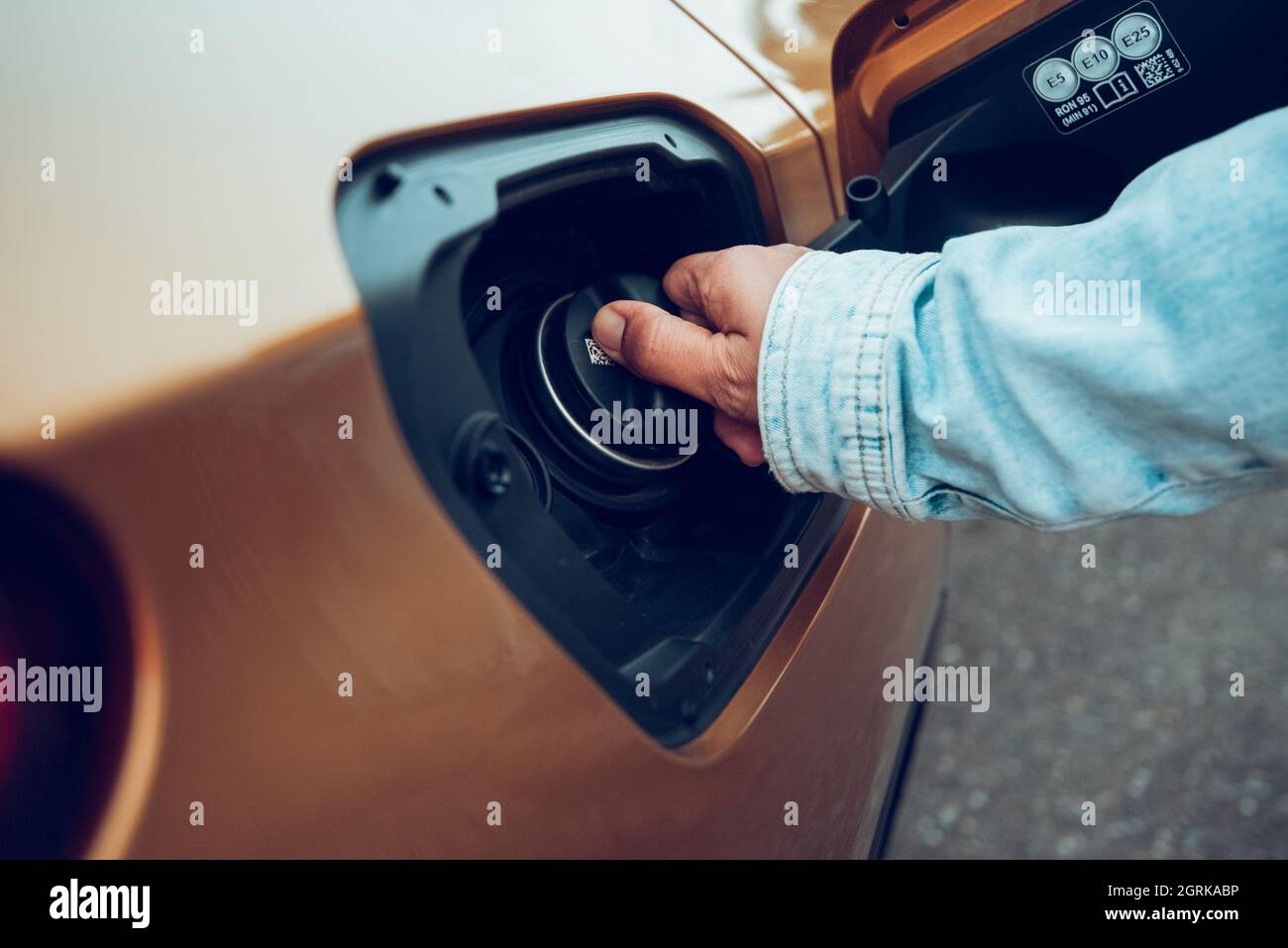 Closeup of man opening fuel tank cover on his car for refueling at gas