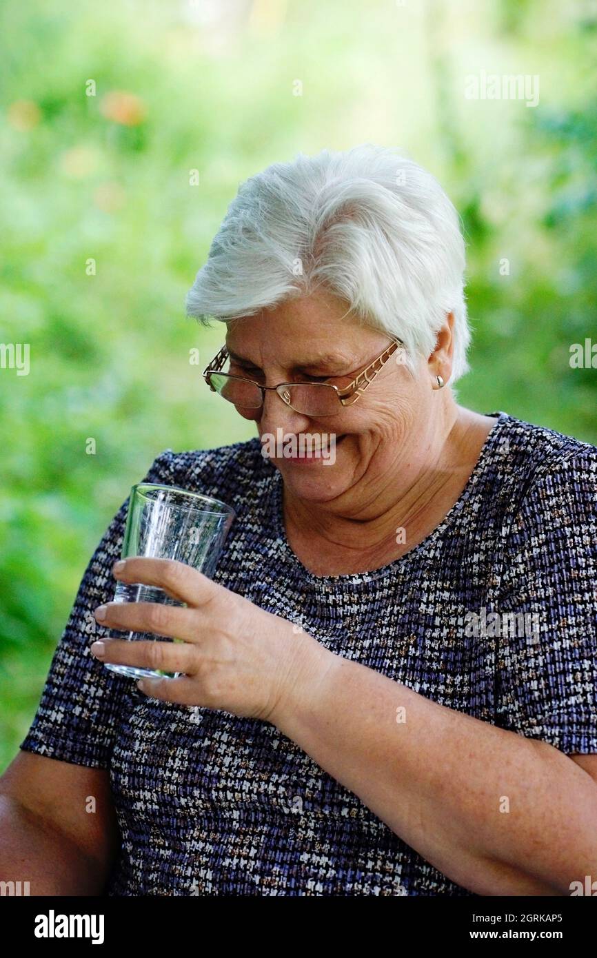 Smiling Senior Woman Holding Drinking Glass Stock Photo
