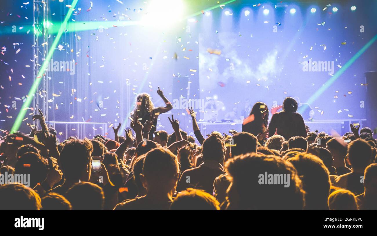 Young people dancing at night club Hands up and multicolored confetti