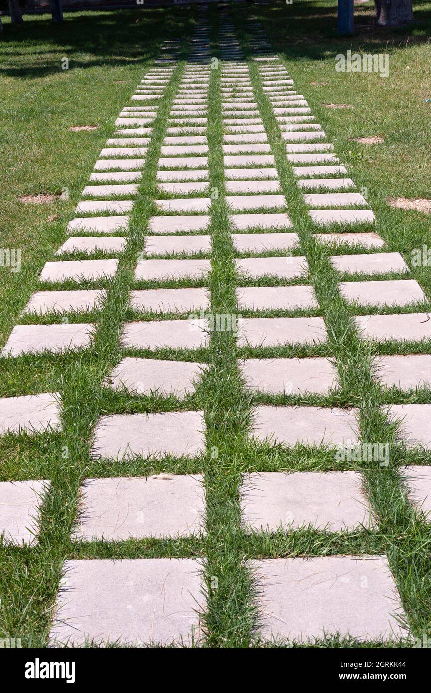 Stones paved on the grassy road Stock Photo