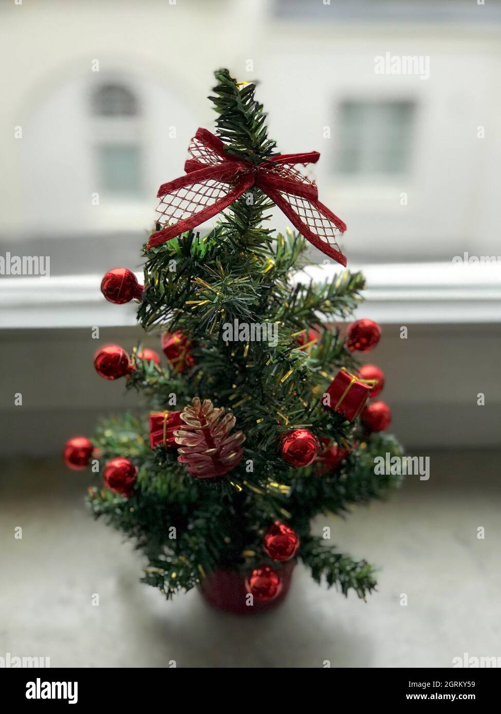 Close-up Of Small Christmas Tree On Window Sill At Home Stock Photo