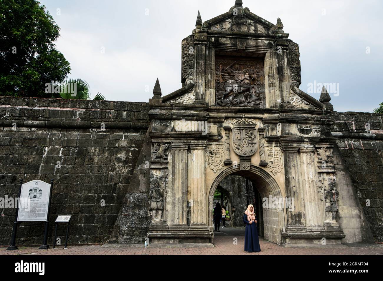 Muslim woman in front of the reconstructed main gate of Fort Santiago in Manila, Philippines. Stock Photo
