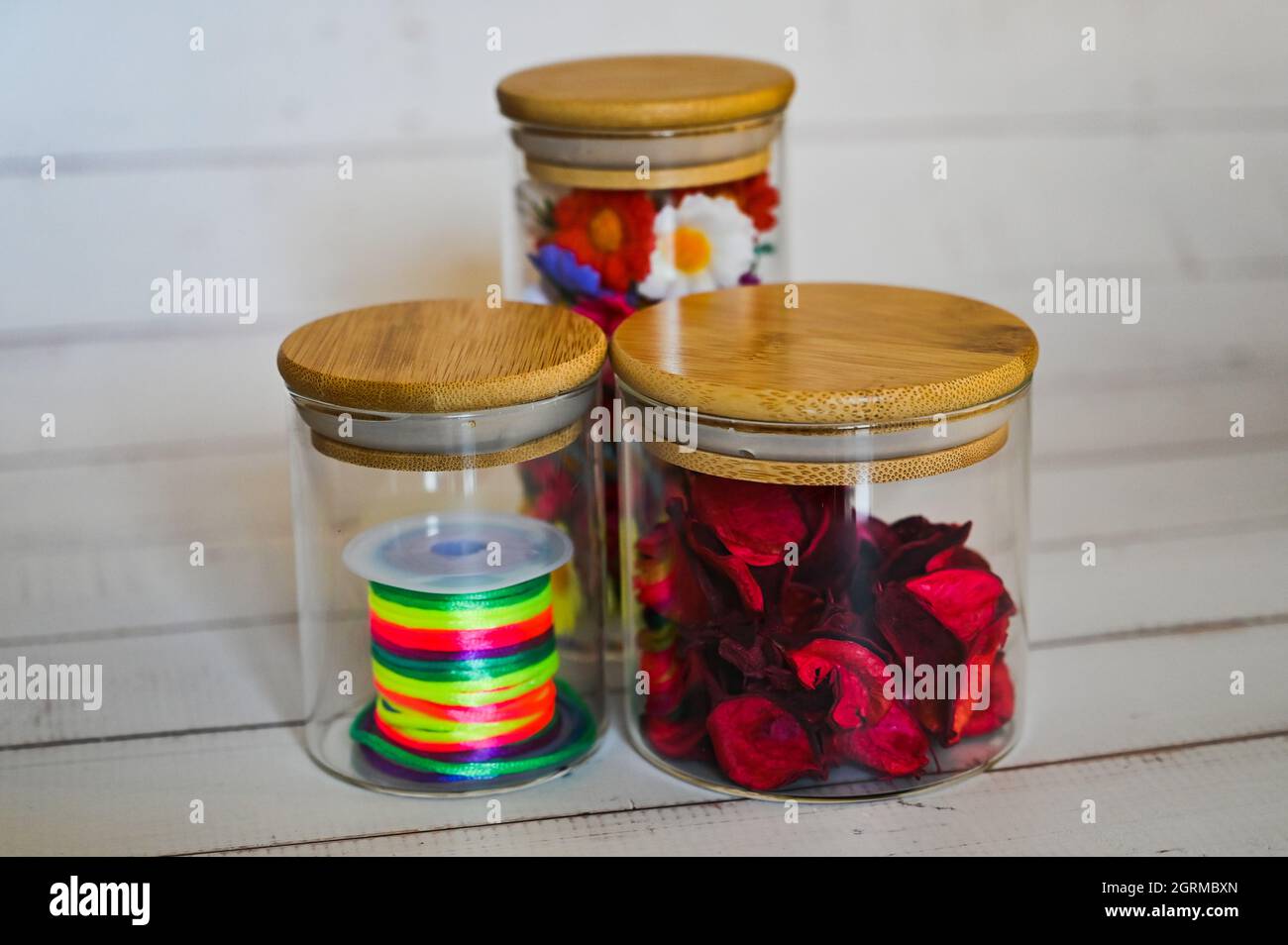 decorative elements for various festive events are placed in glass jars on a light background Stock Photo