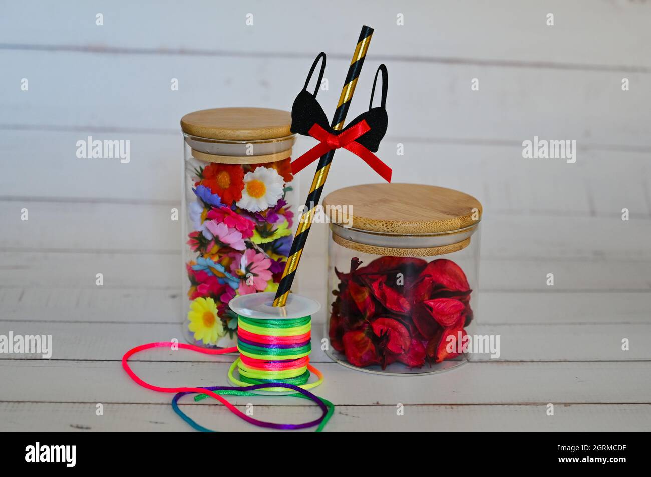decorative elements for various festive events are placed in glass jars on a light background Stock Photo