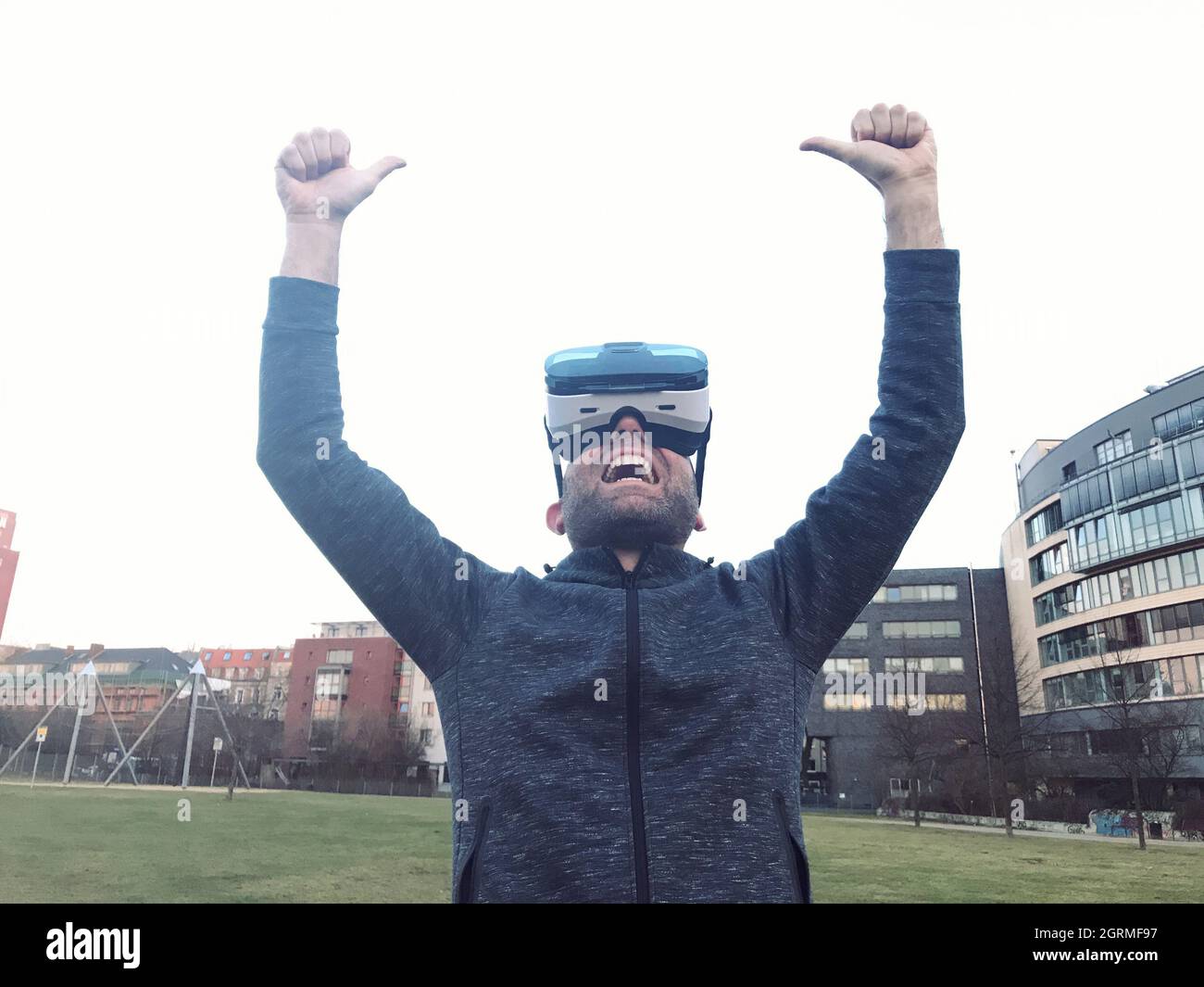 Man Wearing Virtual Reality Simulator In City Against Clear Sky Stock Photo
