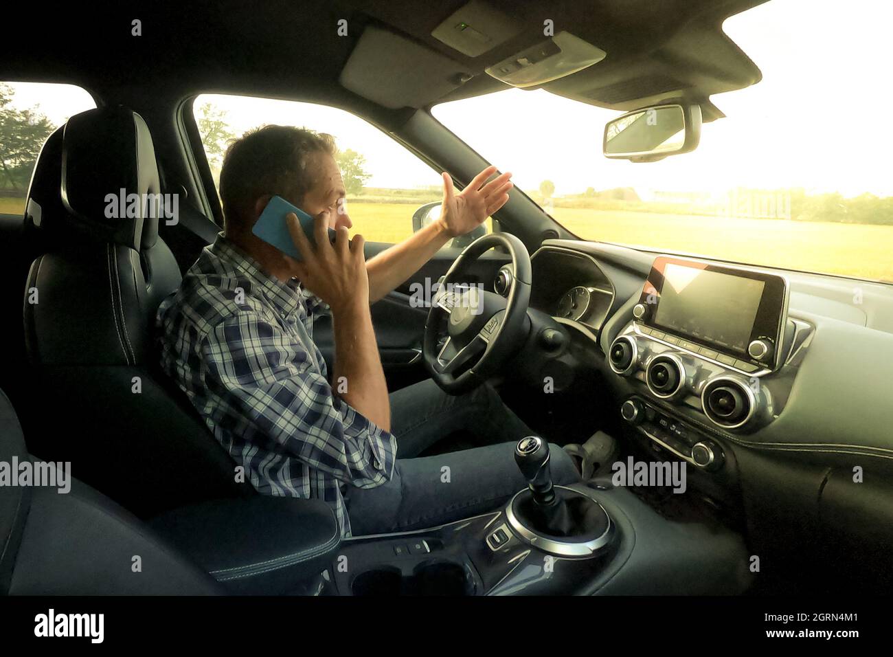 Man drive a car and use infotainment. Driver male reading messages and
