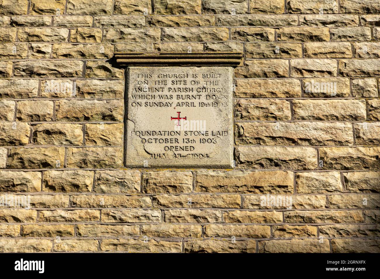Stone plaque on the tower wall of Newchurch Parish Church informing of a rebuild after fire destruction Stock Photo