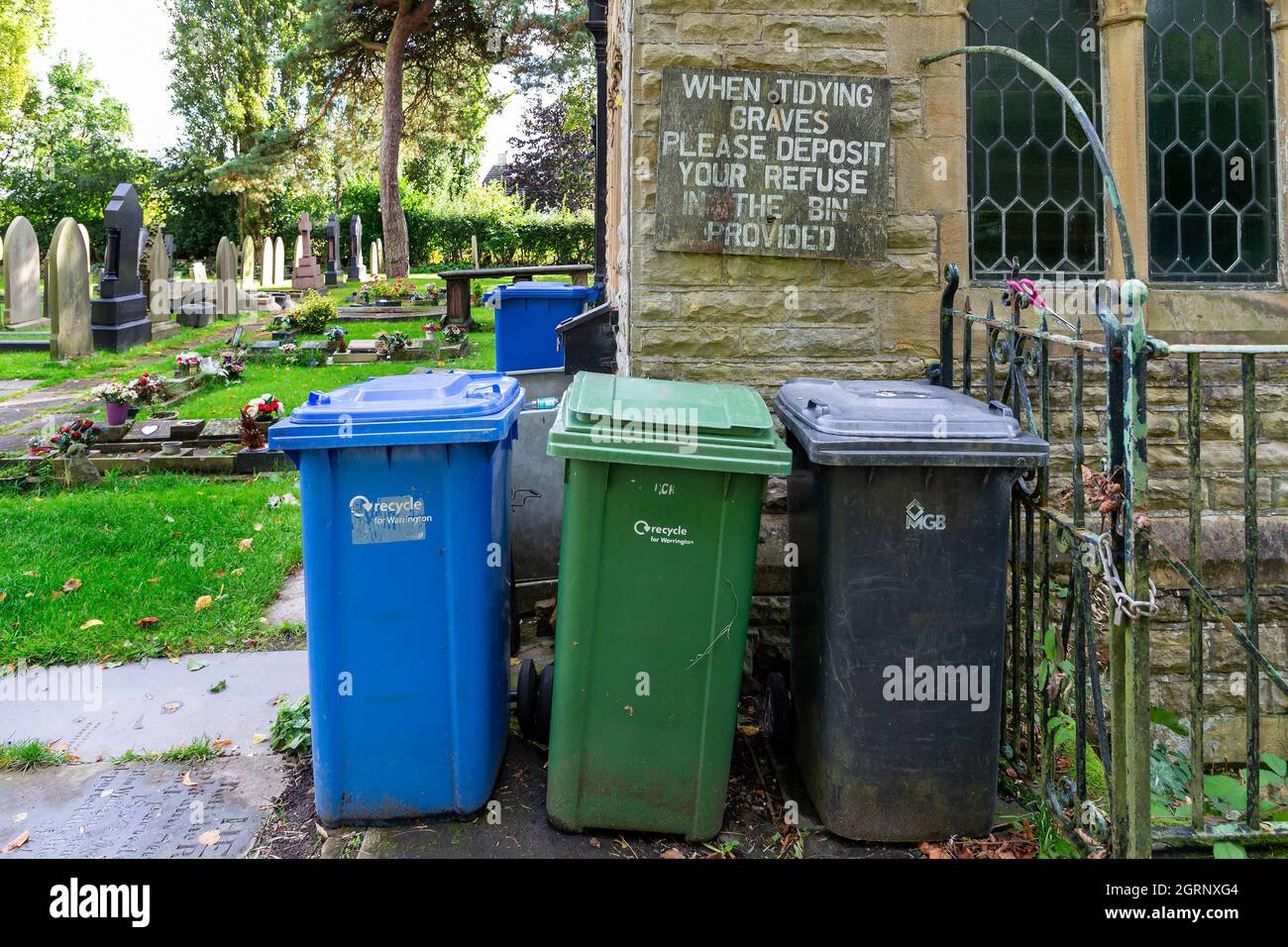 Blue, Green and Blck wheelie bins at the back of Newchurch Parish Church Stock Photo