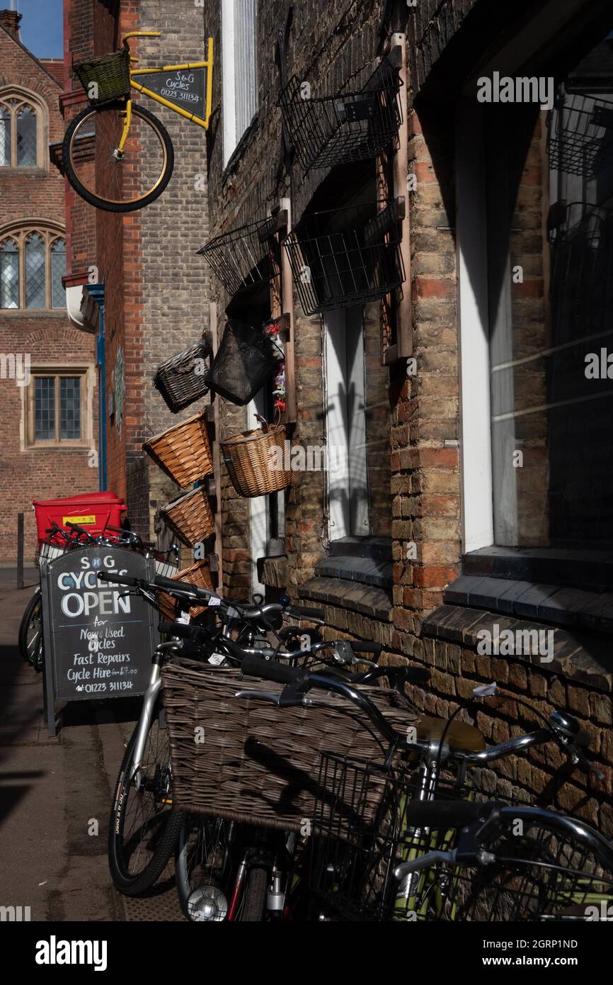 c and g cycles shop in Laundress Lane with retro cycles and wicker baskets outside in narrow street in the University city of Cambridge England Stock Photo