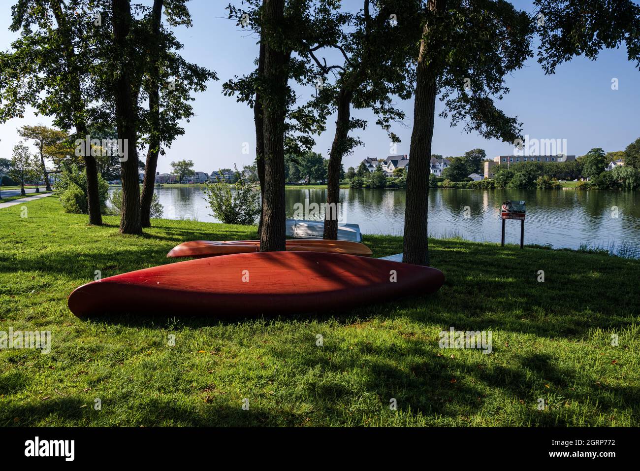 Photo of a red canoe on green grass by Spring Lake at the Jersey Shore