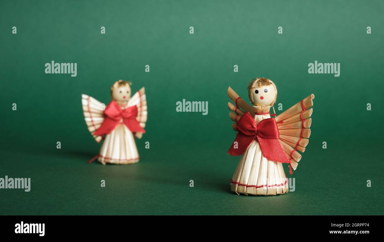 Straw Angels and Green Background. Decorations for Christmas and New Year. Stock Photo