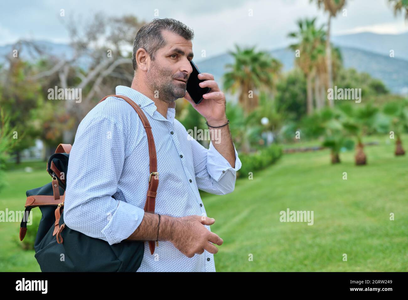 Mature business man talking on the phone outdoors Stock Photo