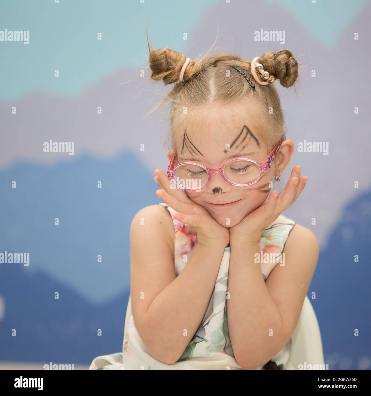 Beautiful girl with Down syndrome with aqua makeup for her birthday Stock Photo