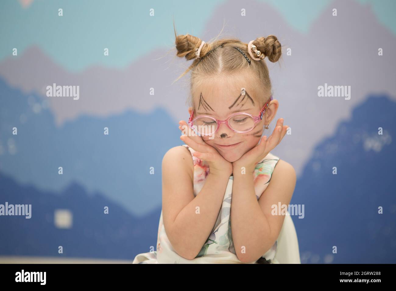 Beautiful girl with Down syndrome with aqua makeup for her birthday Stock Photo