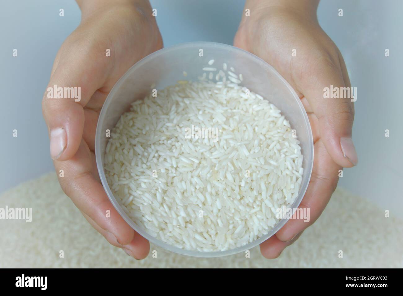 Cropped Hands Holding Rice In Bowl Stock Photo