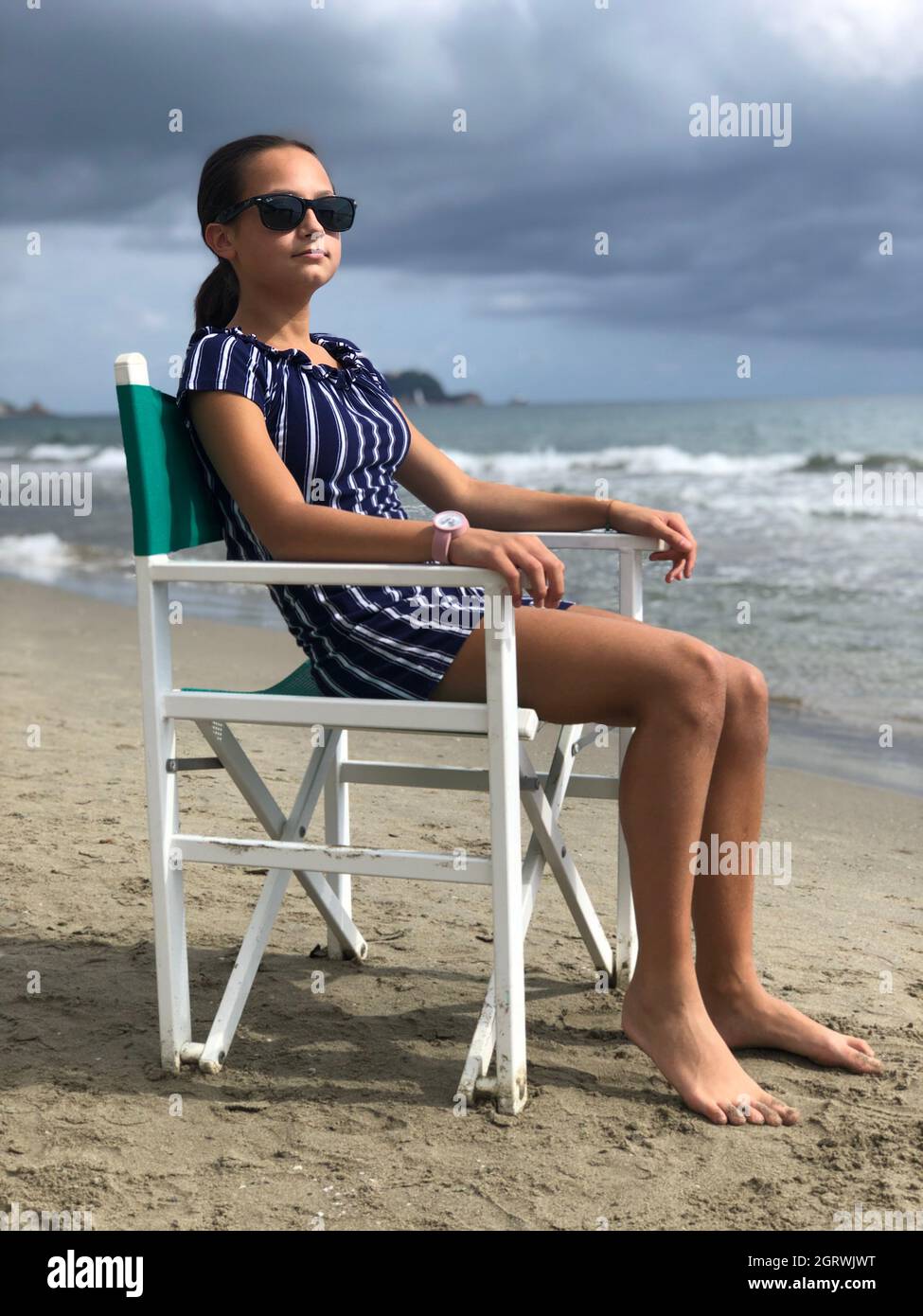 Woman Sitting On Chair At Beach Stock Photo Alamy
