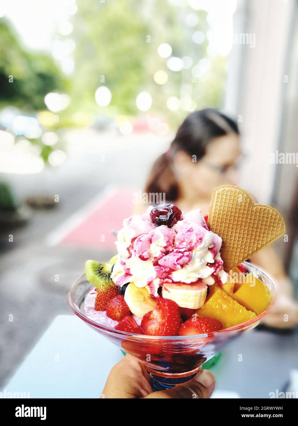 Cropped Image Of Person Holding Ice Cream Sundae Outdoors Stock Photo
