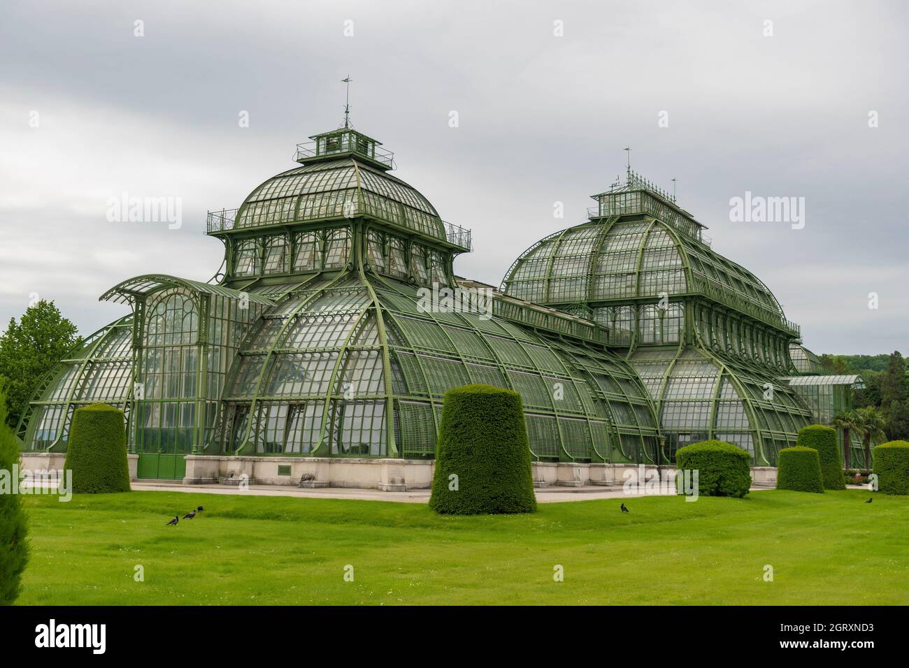 31 May 2019 Vienna, Austria - Palmenhaus building at Schonbrunn gardens. (Palm house) Constructed of iron and glass. Tidy lawns and cloudy day Stock Photo