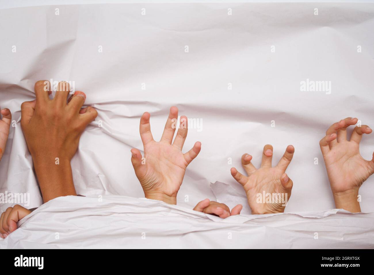 Cropped Hands Of Children On Bed Stock Photo