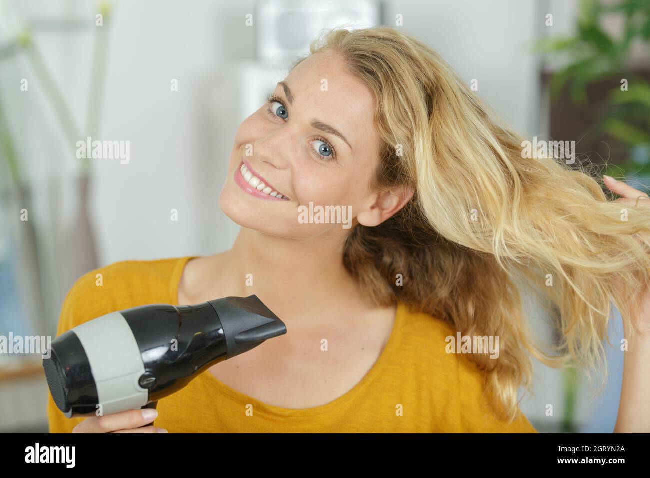 woman with long hair dries hair with a hairdryer Stock Photo - Alamy