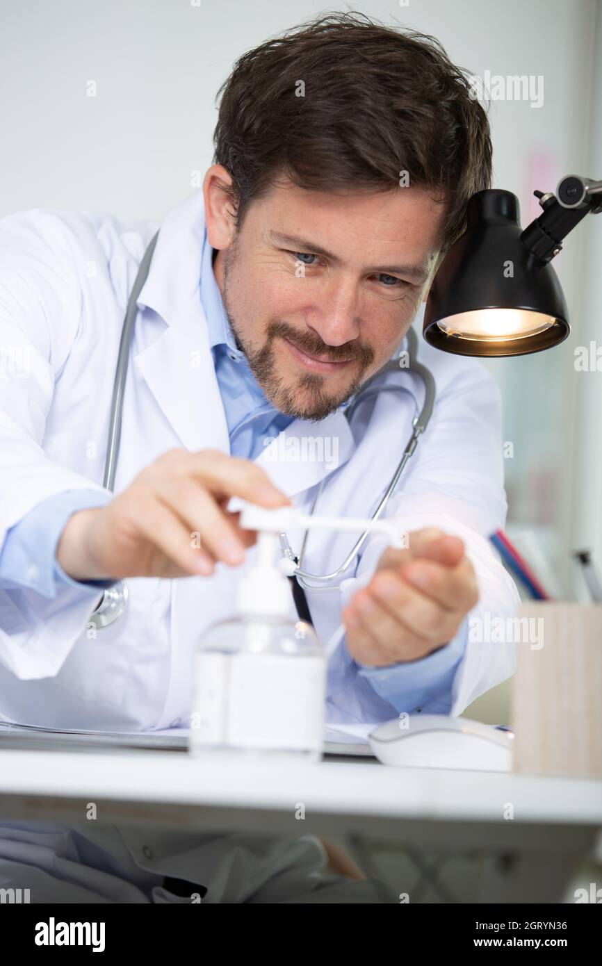 doctor dispensing sanitiser into hand Stock Photo Alamy