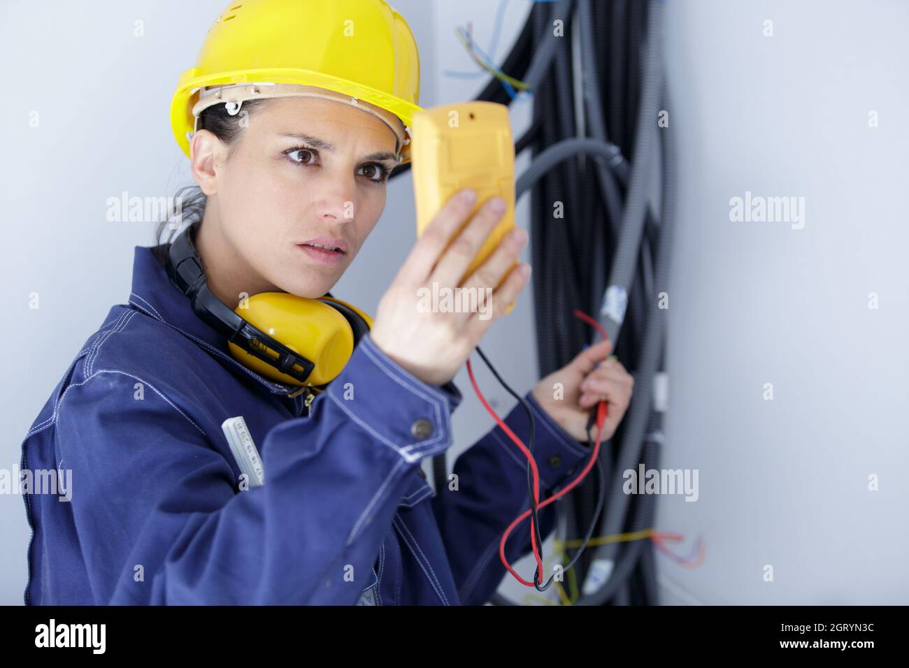 serious female electrician reading multimeter Stock Photo