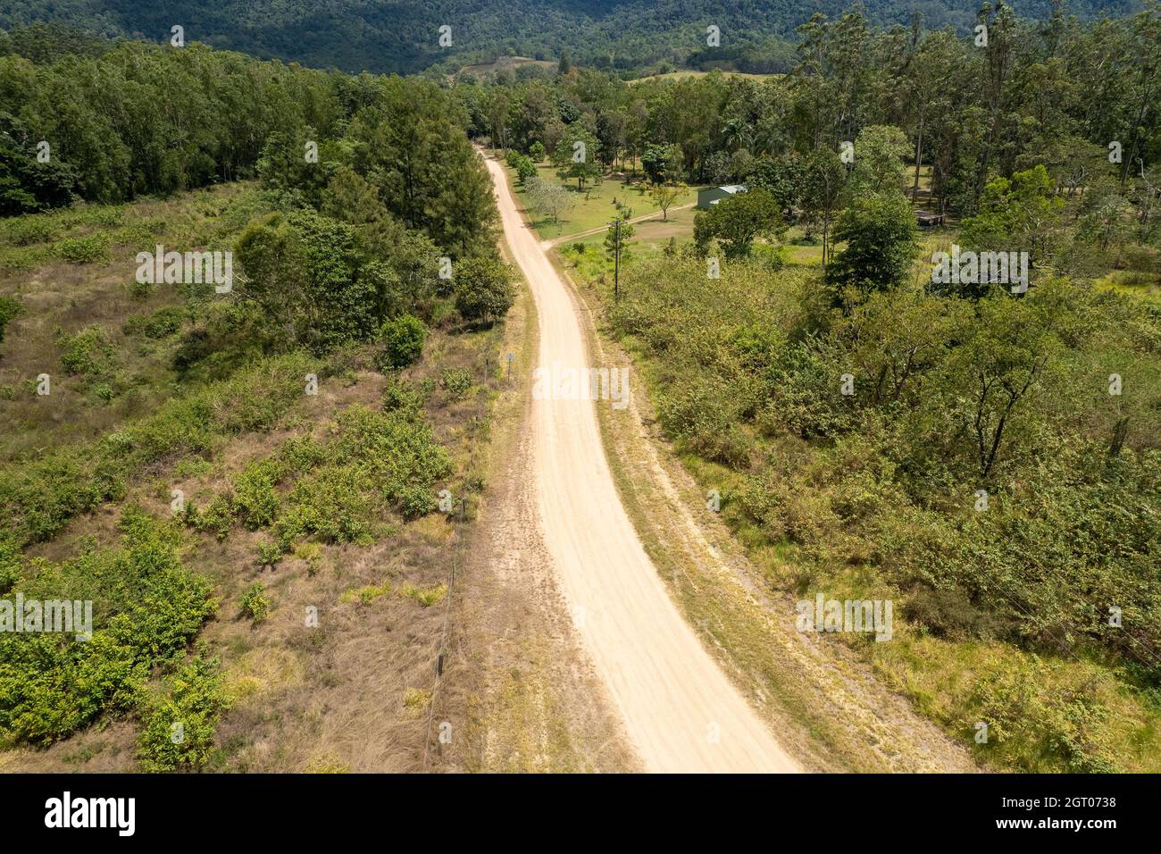 Long Dusty Path Drone aerial of a long dusty road leads to the mountains through a ...