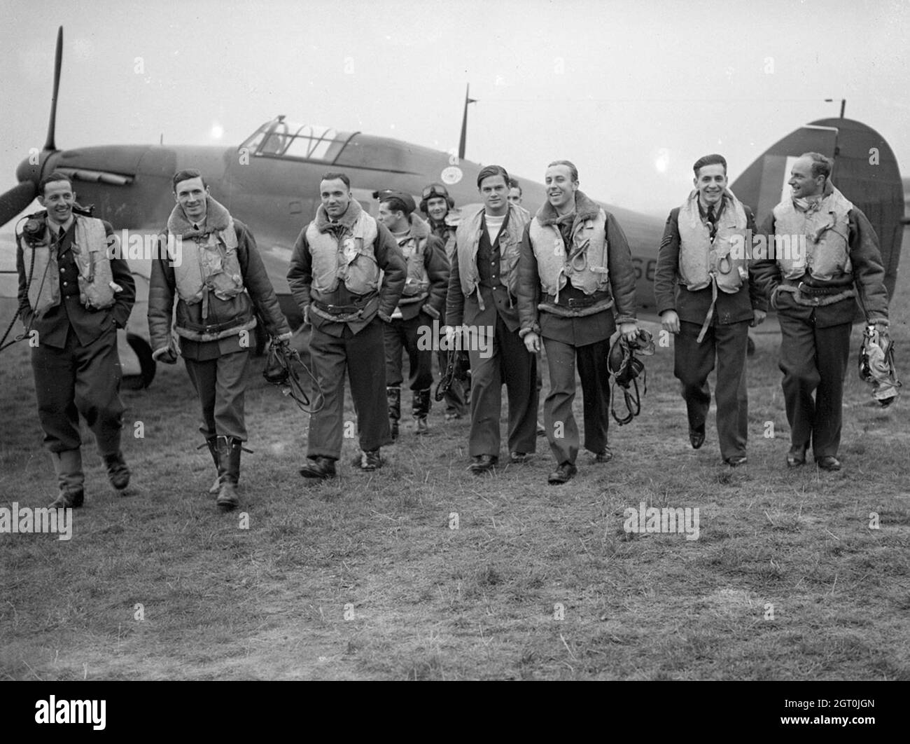 Pilots of No. 303 (Polish) Squadron RAF with one of their Hawker Hurricanes, October 1940. Left to right, in the front row are; Pilot Officer Mirosław Ferić, Flight Lieutenant John A Kent (Commander of 'A' Flight), Flying Officer Bogdan Grzeszczak, Pilot Officer Jerzy Radomski, Pilot Officer Witold Łokuciewski, Pilot Officer Bogusław Mierzwa (obscured by Łokuciewski), Flying Officer Zdzisław Henneberg, Sergeant Jan Rogowski and Sergeant Eugeniusz Szaposznikow. In the centre, to the rear of this group, wearing helmet and goggles is Flying Officer Jan Zumbach. Stock Photo