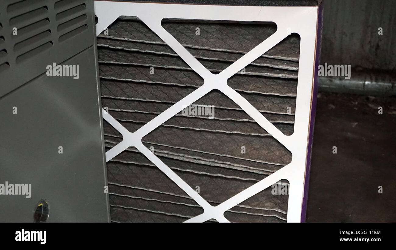 Changing out an old furnace air filter and replacing with a new clean