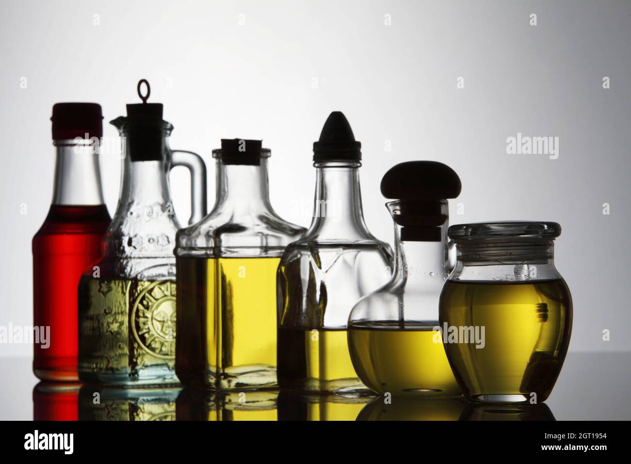 Palm Oil, Sesame Seed Oil, Olive Oil, Grape Seed Oil And Corn Oil In Glass Bottle Over White Stock Photo