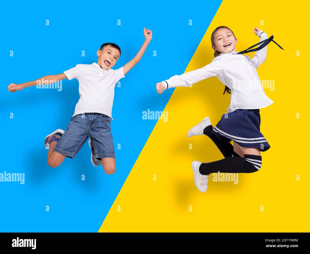 Happy student boy and girl jumping.Isolated on colorful background. Stock Photo