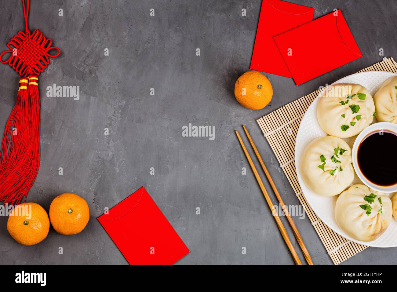 High Angle View Of Tangerine Fruits And Dumplings, Red Envelopes On Table Stock Photo