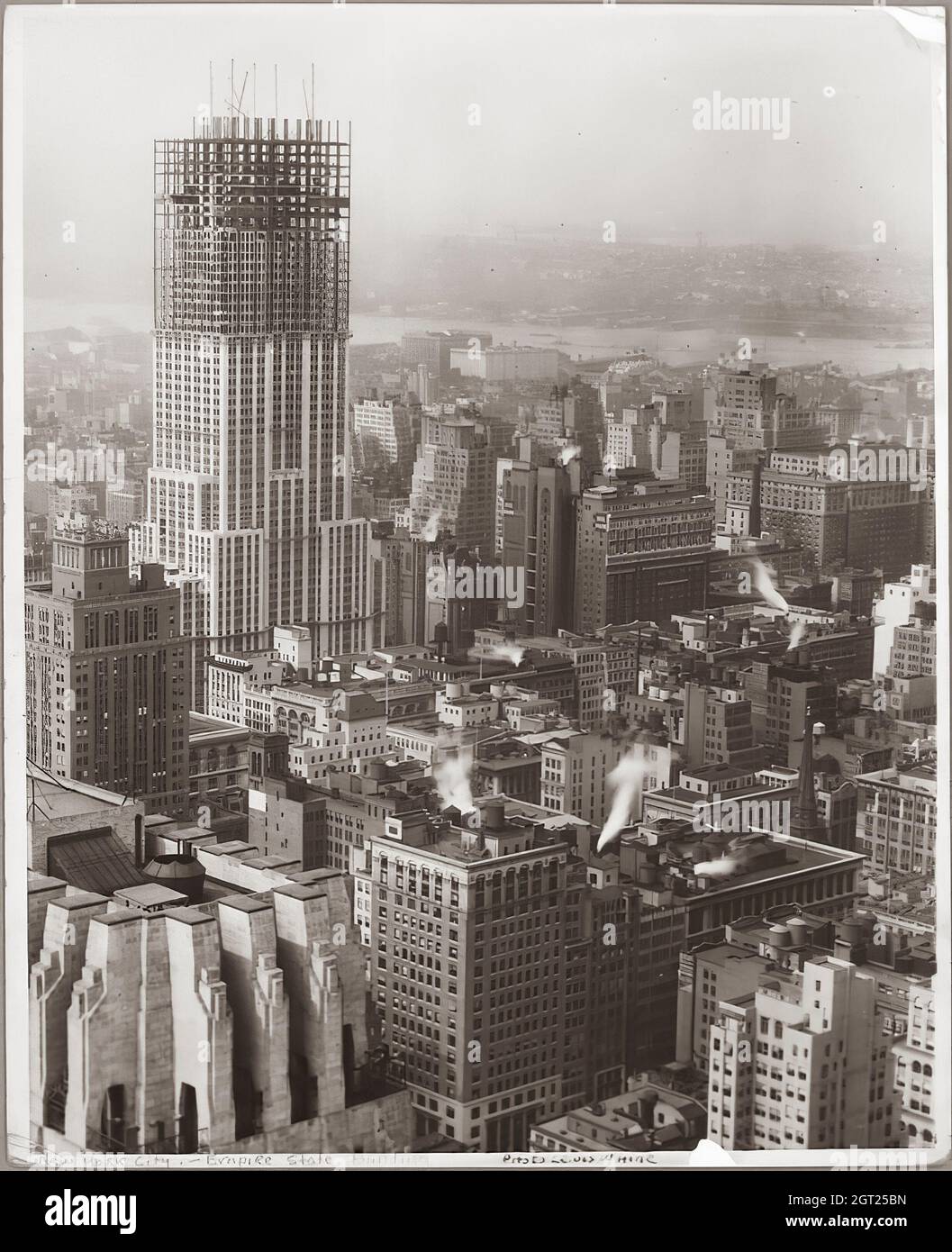 EMPIRE STATE BUILDING NY,NY 1930 - 1931. General and detailed views of the Empire State Building under construction showing workers performing various tasks including positioning, welding and riveting steel, hoisting materials and supplies, and operating and repairing machinery. There are also birds-eye views of midtown Manhattan showing other buildings under construction. Photographs by: Hine, Lewis Wickes, 1874-1940 . Stock Photo
