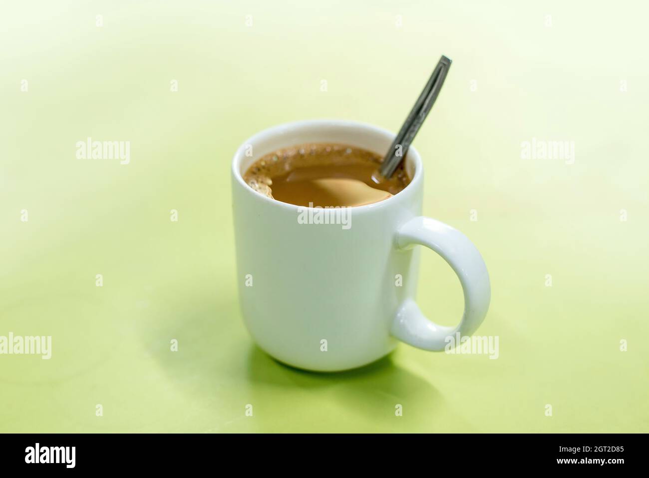 Close-up Of Coffee Cup Against Green Background Stock Photo
