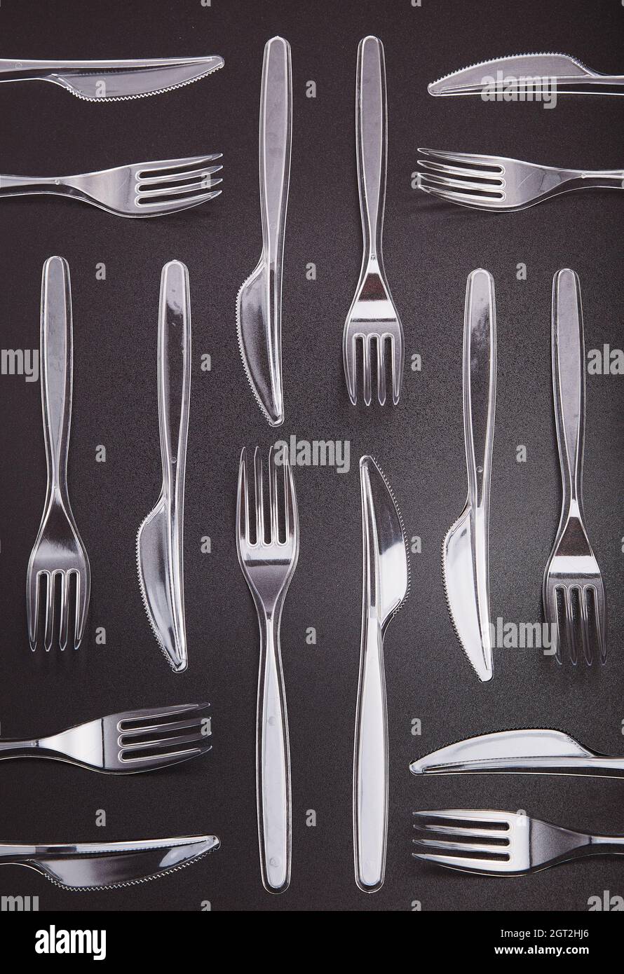 Plastic Forks And Knives Over Grey Background. Collecting Plastic Waste