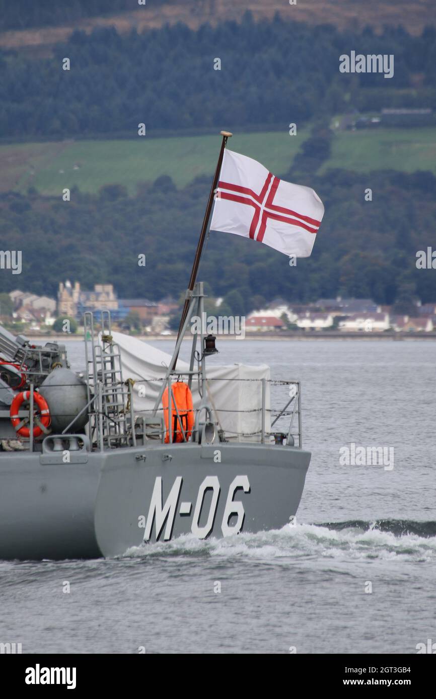 The ensign of the Latvian Navy, being flown from LVNS Talivaldis (M-06), an Alkmaar-class (Tripartite) minehunter operated by the Latvian Navy. The vessel is seen passing Greenock on the Firth of Clyde, as she heads out to take part in the military exercises Dynamic Mariner 2021 and Joint Warrior 21-2. This particular vessel once served in the Royal Netherlands Navy before being decommissioned and sold to Latvia. Stock Photo
