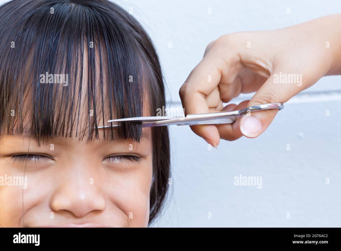 Cropped Hand Cutting Girl Hair Stock Photo - Alamy