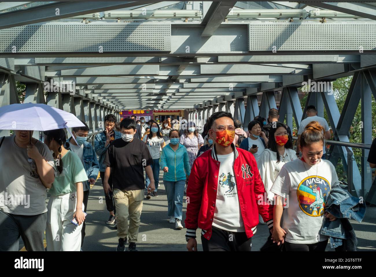 People walk on an overpass in Xidan business district in Beijing, China. 02-Oct-2021 Stock Photo