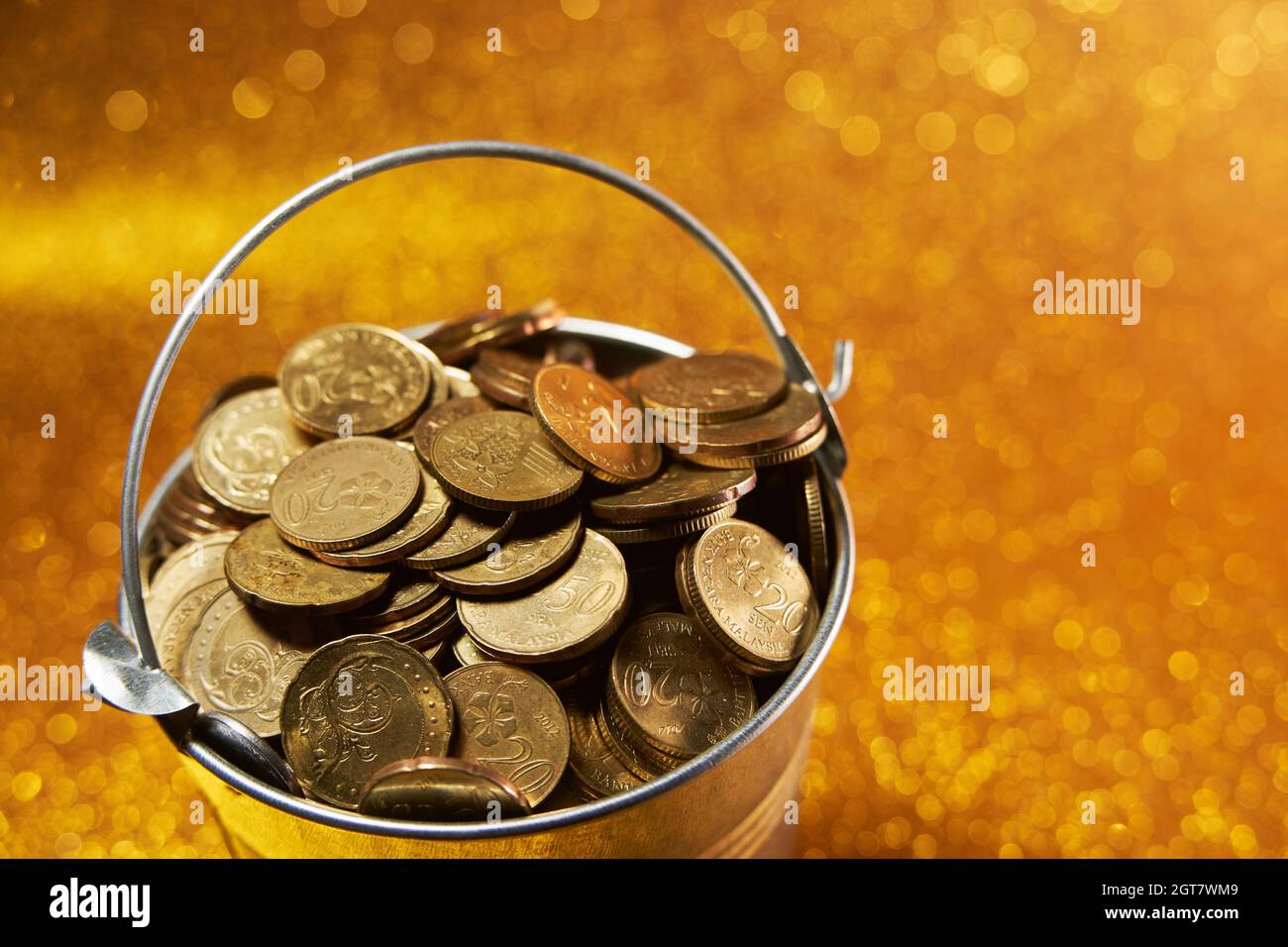 Bucket Full Of Coin On Gold Glittering Background Stock Photo - Alamy
