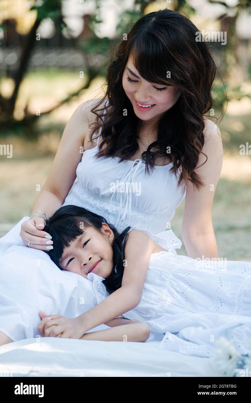 Girl sitting knees up smiling hi-res stock photography and images - Alamy