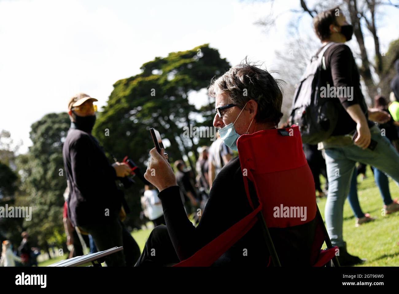 Melbourne, Australia, 2 October, 2021. A lady sits in a chair watching during the 'Rise Up! Melbourne Rally for Health Rights and Freedom' in The Royal Botanic Gardens. Melbourne continues its hard lockdowns following Premier Daniel Announcement that all authorized workers must be mandatorily vaccinated by October 15. Credit: Dave Hewison/Speed Media/Alamy Live News Stock Photo