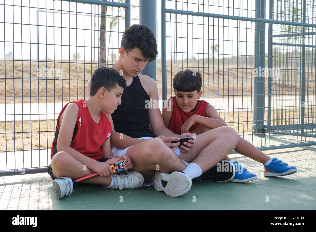 Three brothers looking something on the smartphone. Stock Photo