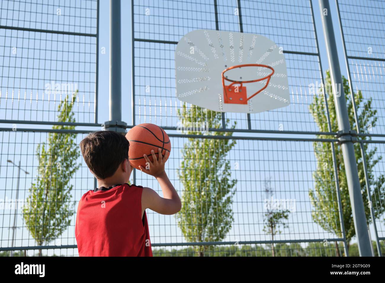 Basketball kid player throwing the ball to the basket Stock Photo Alamy