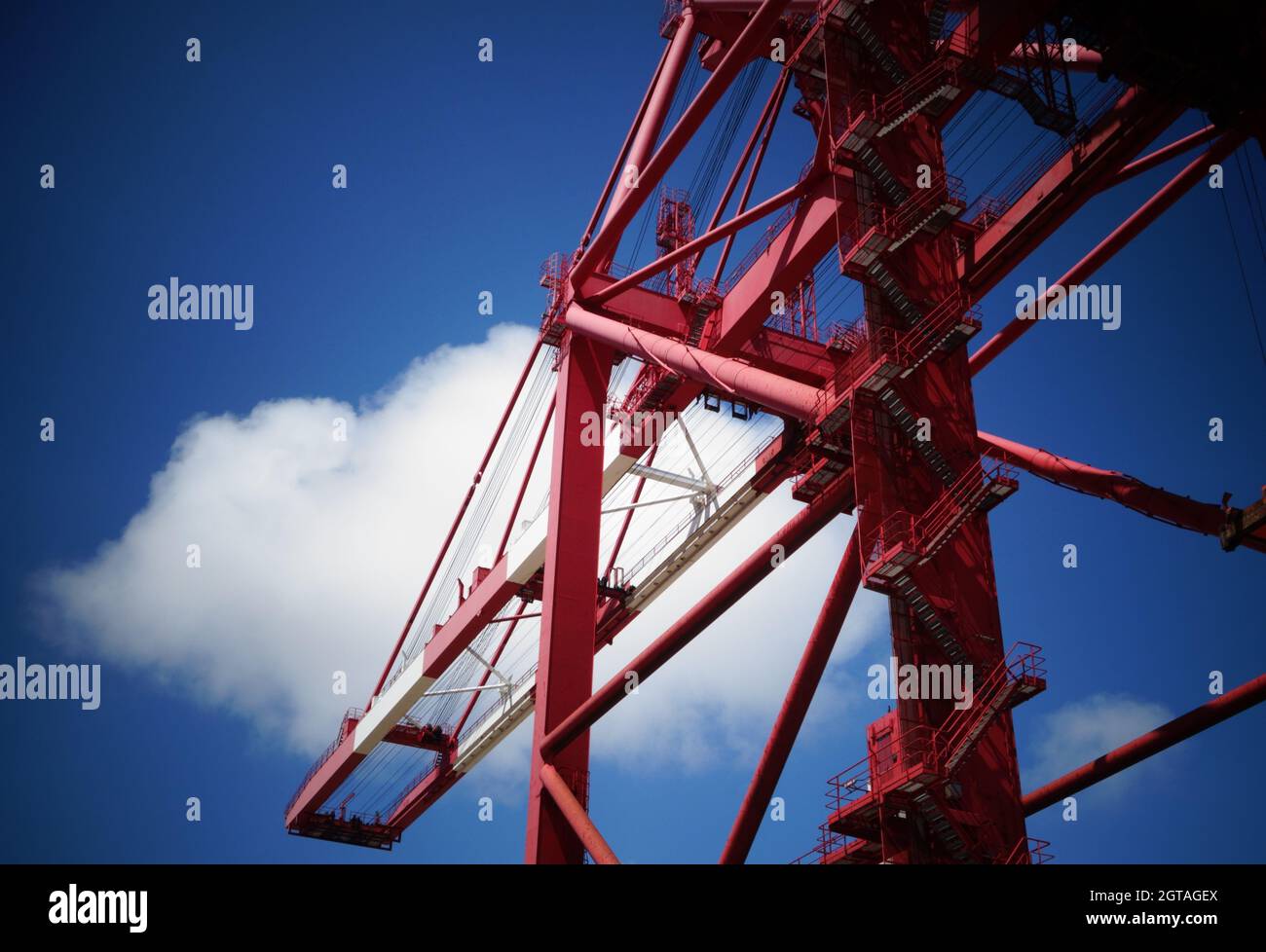 Port red cargo container gantry crane abstract structure with blue sky