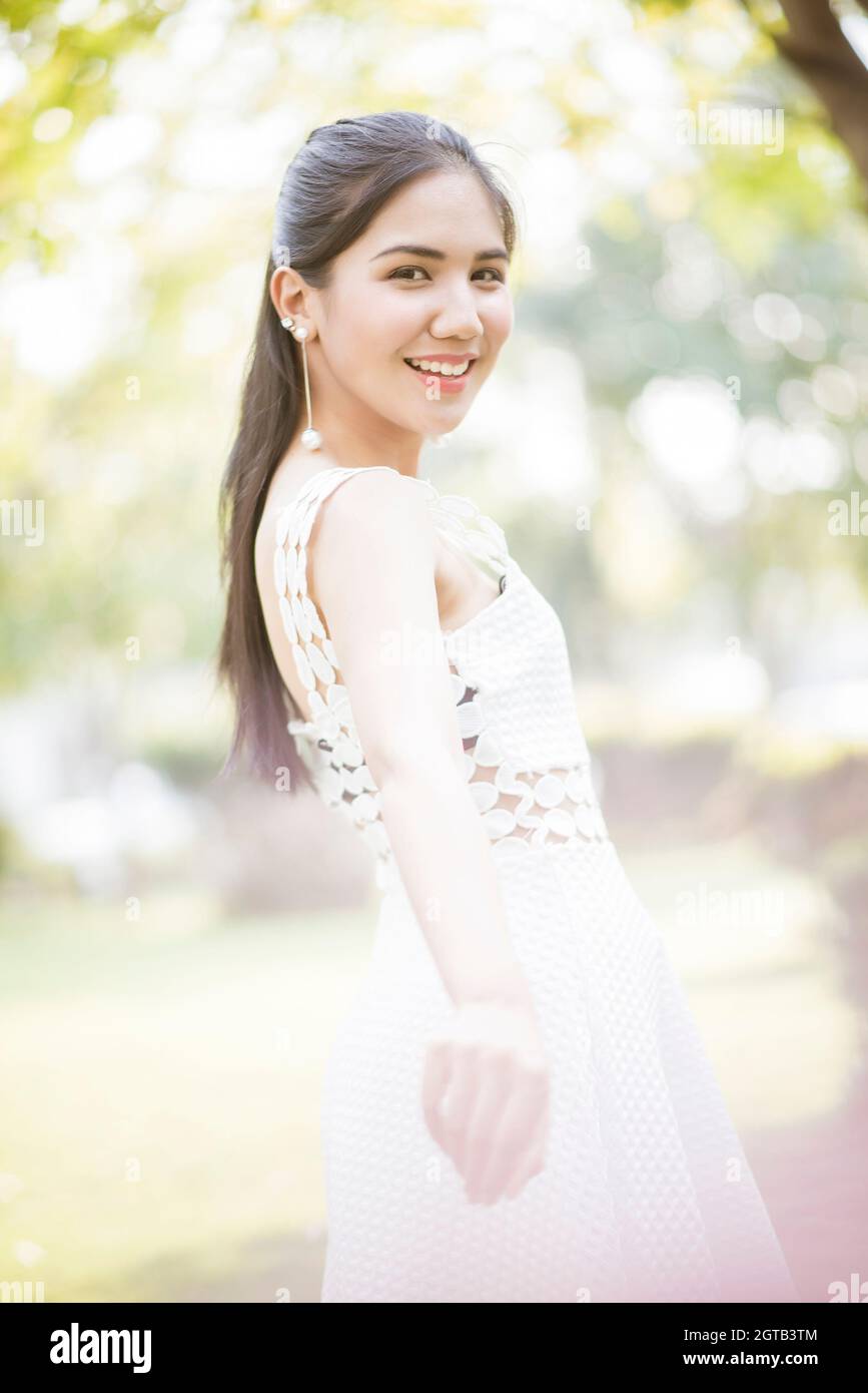 Side View Portrait Of Smiling Young Woman Standing Outdoors Stock Photo